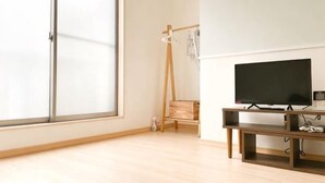 A room with a large window, a television on a wooden stand, and a wooden floor. - Vacation Stay Fushimiinari (Kyoto)