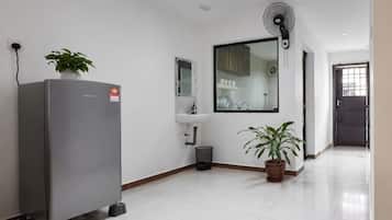 A modern kitchen with a refrigerator, sink, and potted plants.