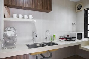 A kitchen with a double sink, white countertop, and wooden cabinets. - IpohComfortHomestay, 4-10pax 10mins to attraction (Ipoh)