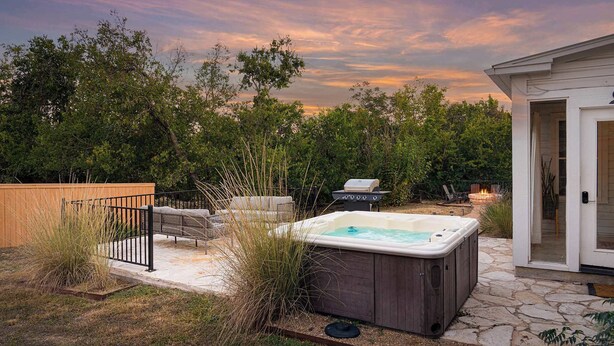 A backyard with a hot tub, outdoor seating, a grill, and a fire pit. - Moment in Time - Hot Tub & Fire Pit (Fredericksburg)