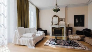 A room with a bed, a fireplace, a rug, and a hanging light fixture. - Domaine de la Grotte (Wine Estate) (Sore)