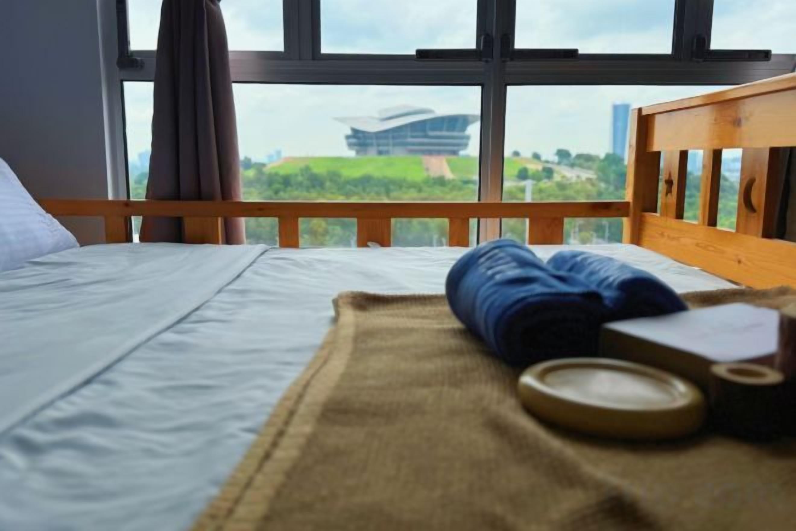 A bed with a view of a building through a window.