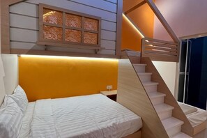 Un dormitorio con cama, ventana con celosía decorativa y escalera con barandilla de madera.