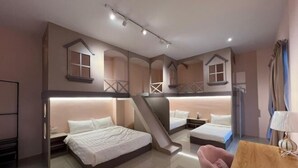 Ein Hotelzimmer mit Stockbett, Schreibtisch, Stuhl und Treppe.