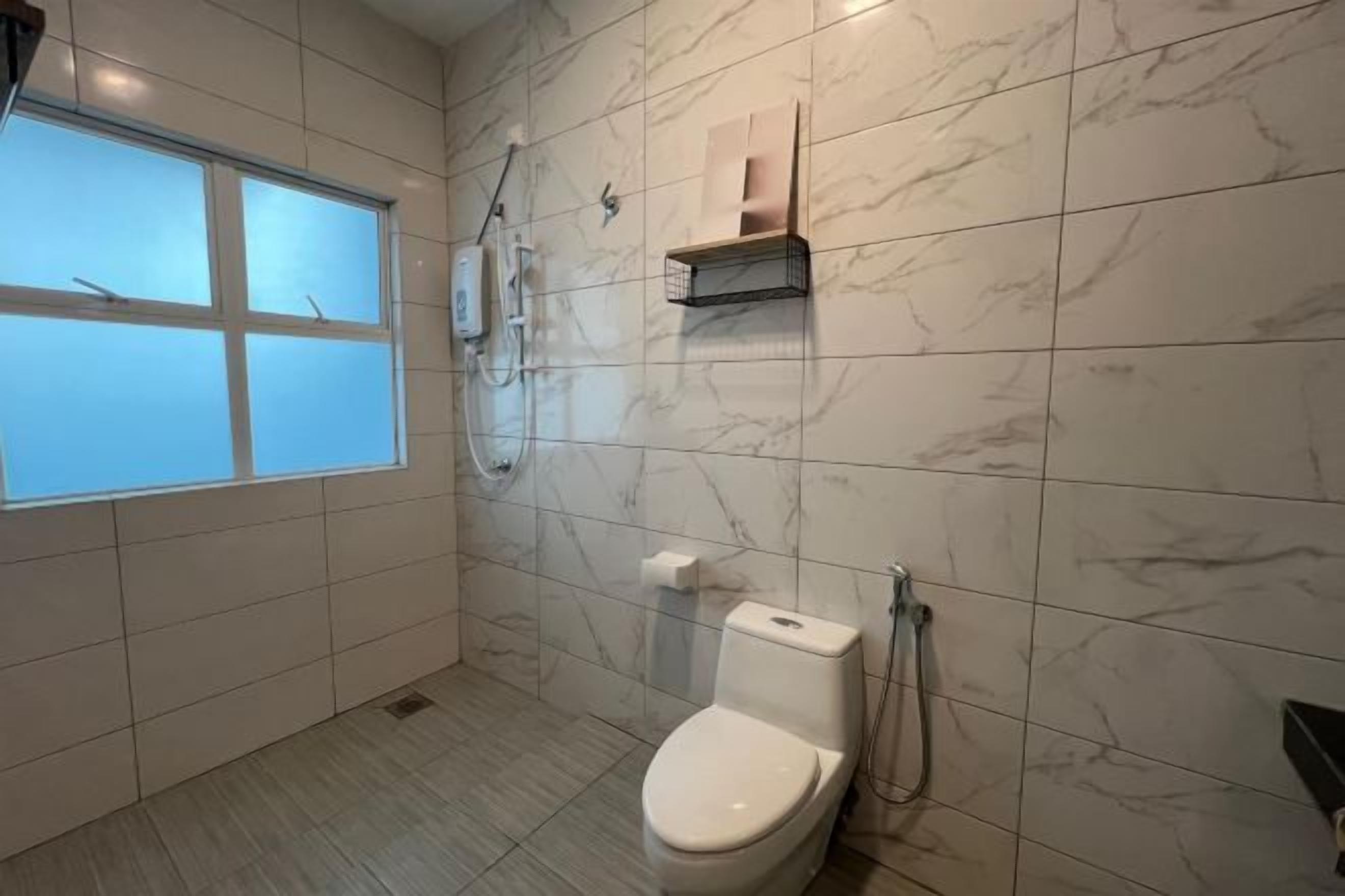 Un baño con inodoro, ducha y ventana.