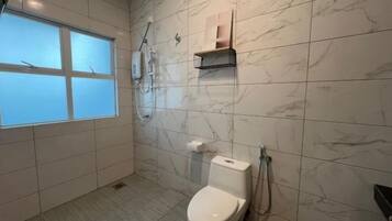 Un baño con inodoro, ducha y ventana.