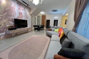Una sala moderna con un televisor de pantalla plana, un sofá y una alfombra estampada.