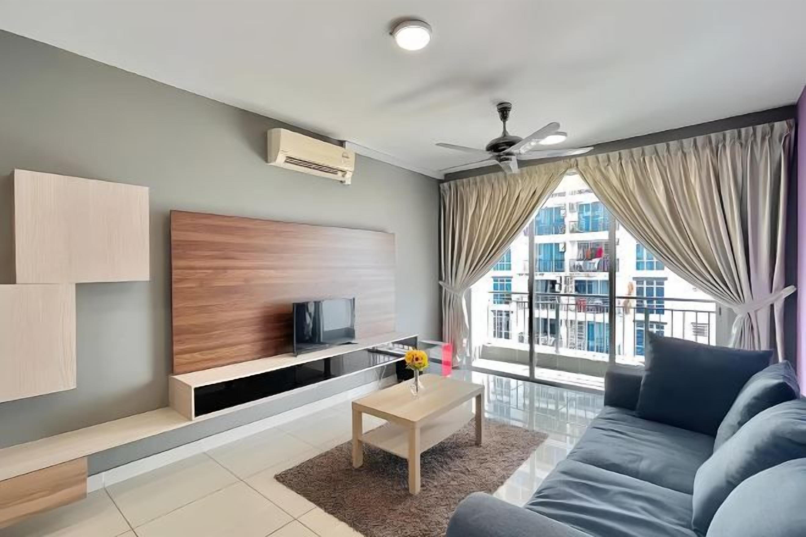 A modern living room with a sofa, a coffee table, a TV on a wooden stand, and a large window with curtains.