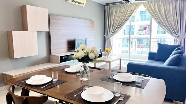 Una sala moderna con comedor, un sofá azul y un ventanal con cortinas.