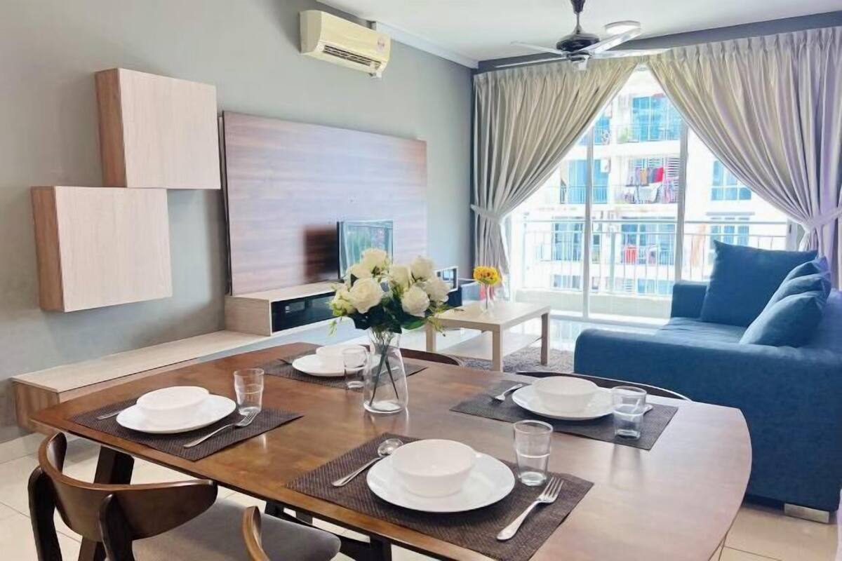Ein modernes Wohnzimmer mit Essbereich, einer Couch und einem großen Fenster mit Vorhängen.