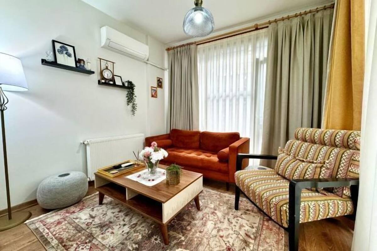 Ein Wohnzimmer mit Sofa, Sessel, Couchtisch und Dekorationselementen.