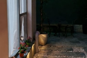 Una escalera de piedra que lleva a una terraza de madera con una mesa y sillas.