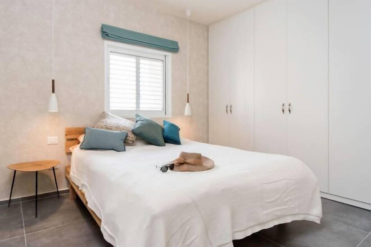 Une chambre à coucher avec un lit, une table de chevet et une armoire.