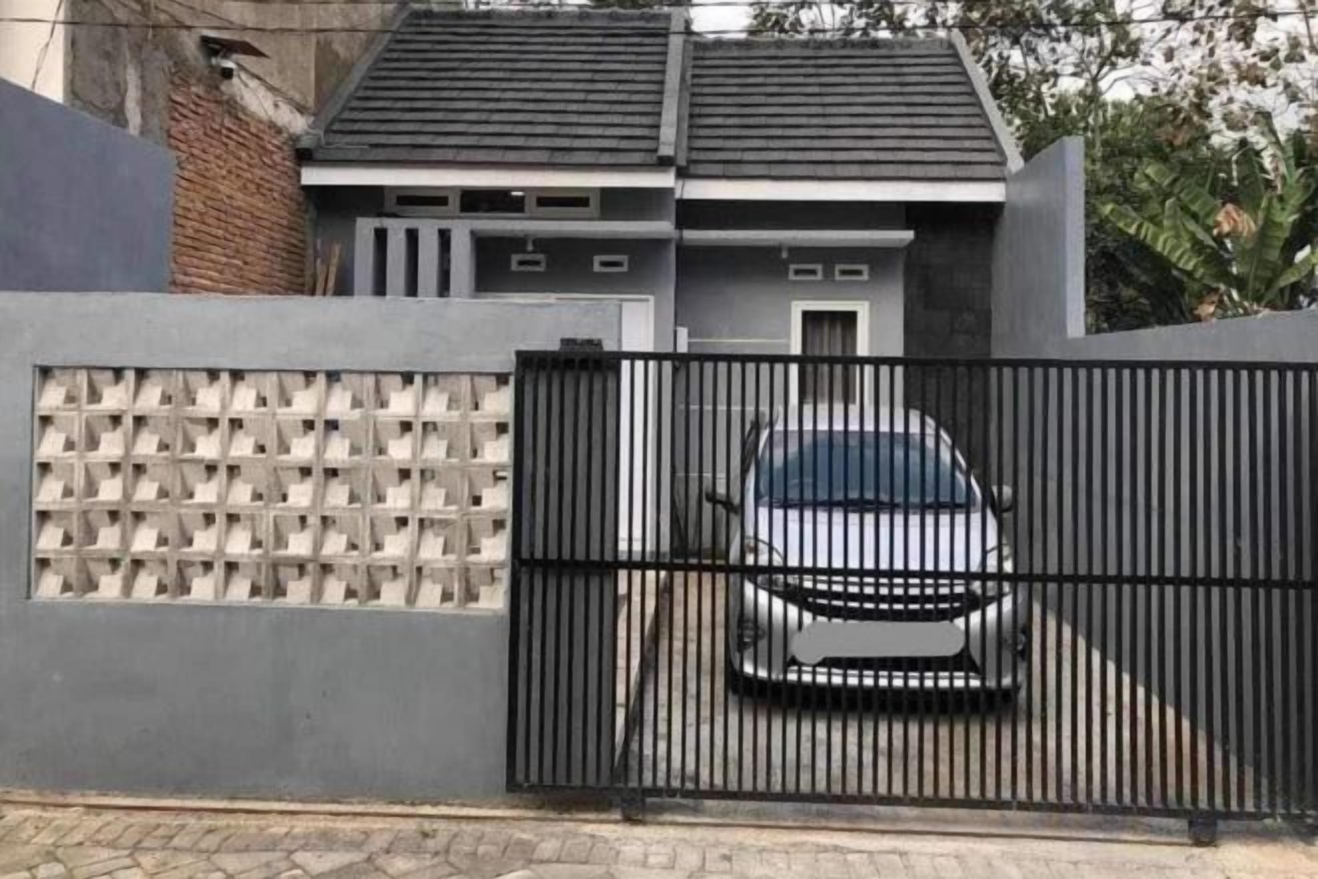 A gated residential property with a car parked in front.