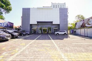 A building with a parking lot and a gated entrance. - RedDoorz @ First Homestay Bypass Kuta (Bali)