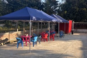 A covered outdoor seating area with tables and chairs. - Laos Supre Hotel (Luang Prabang)