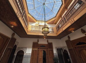 Een weelderig interieur met een hoog, koepelvormig plafond en ingewikkeld houtsnijwerk.