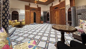 An ornate interior with a tiled floor, wooden furniture, and intricate wall designs. - Welcoming to room in Riad bed & breakfast with AC in charming Fez authentic (Fès)
