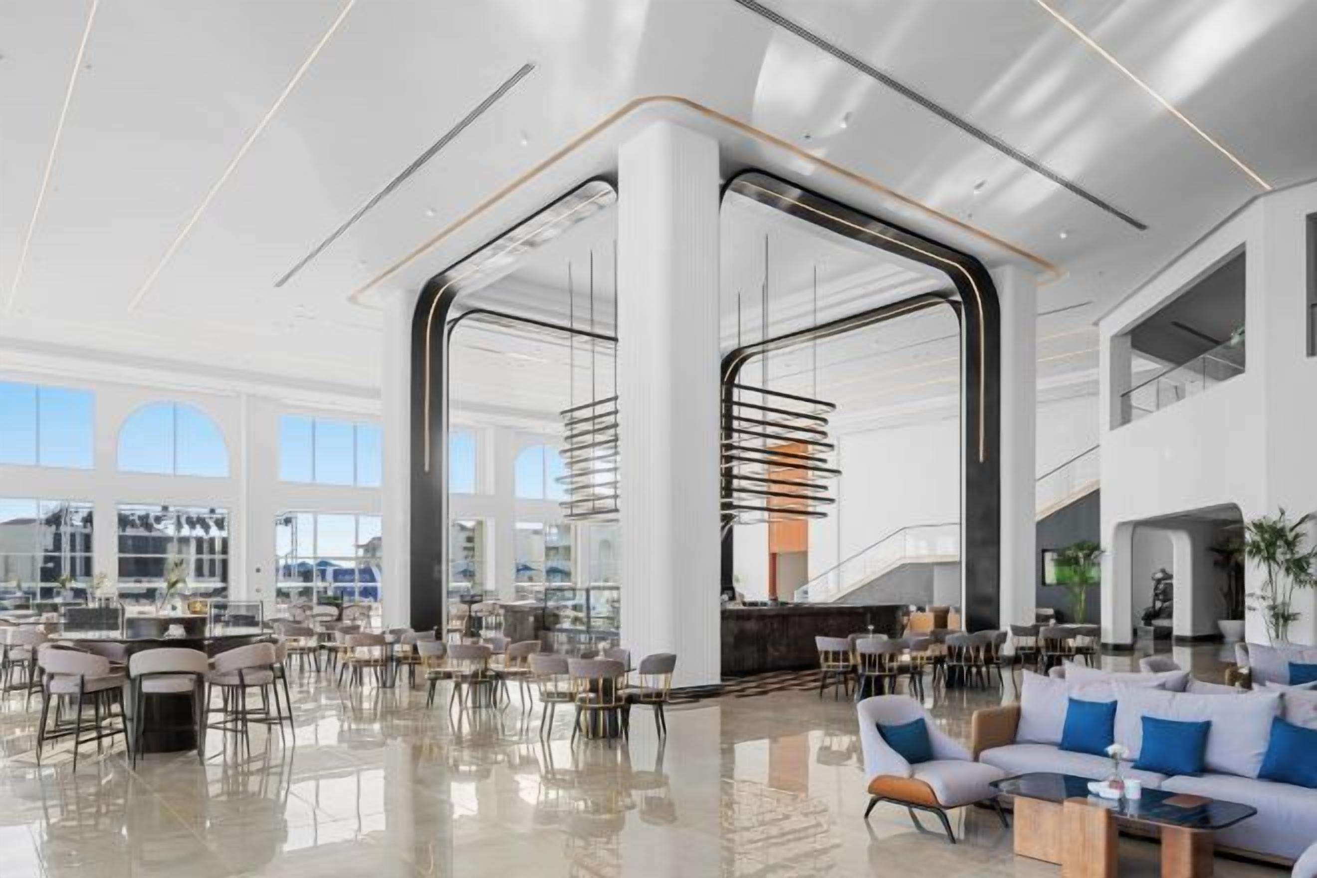 Eine geräumige Lobby mit hohen Decken, großen Fenstern und modernen Möbeln.