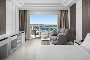 Ein modernes Hotelzimmer mit Balkon, einer Couch, einem Esstisch und einem kleinen Couchtisch.