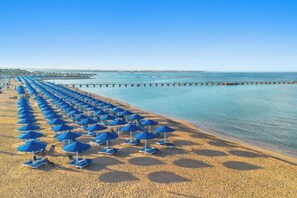 A beach with rows of blue umbrellas and lounge chairs. - Albatros Makadi Resort - 24 HRS All Inclusive (Hurghada)