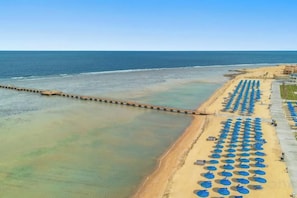 A beach with a pier extending into the water, rows of umbrellas, and a clear sky. - Albatros Makadi Resort - 24 HRS All Inclusive (Hurghada)