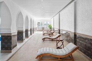 A corridor with lounge chairs, a plant, and a view of the outdoors. - Albatros Makadi Resort - 24 HRS All Inclusive (Hurghada)