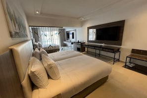 A modern hotel room with a large bed, a desk, and a TV. - Albatros Makadi Resort - 24 HRS All Inclusive (Hurghada)