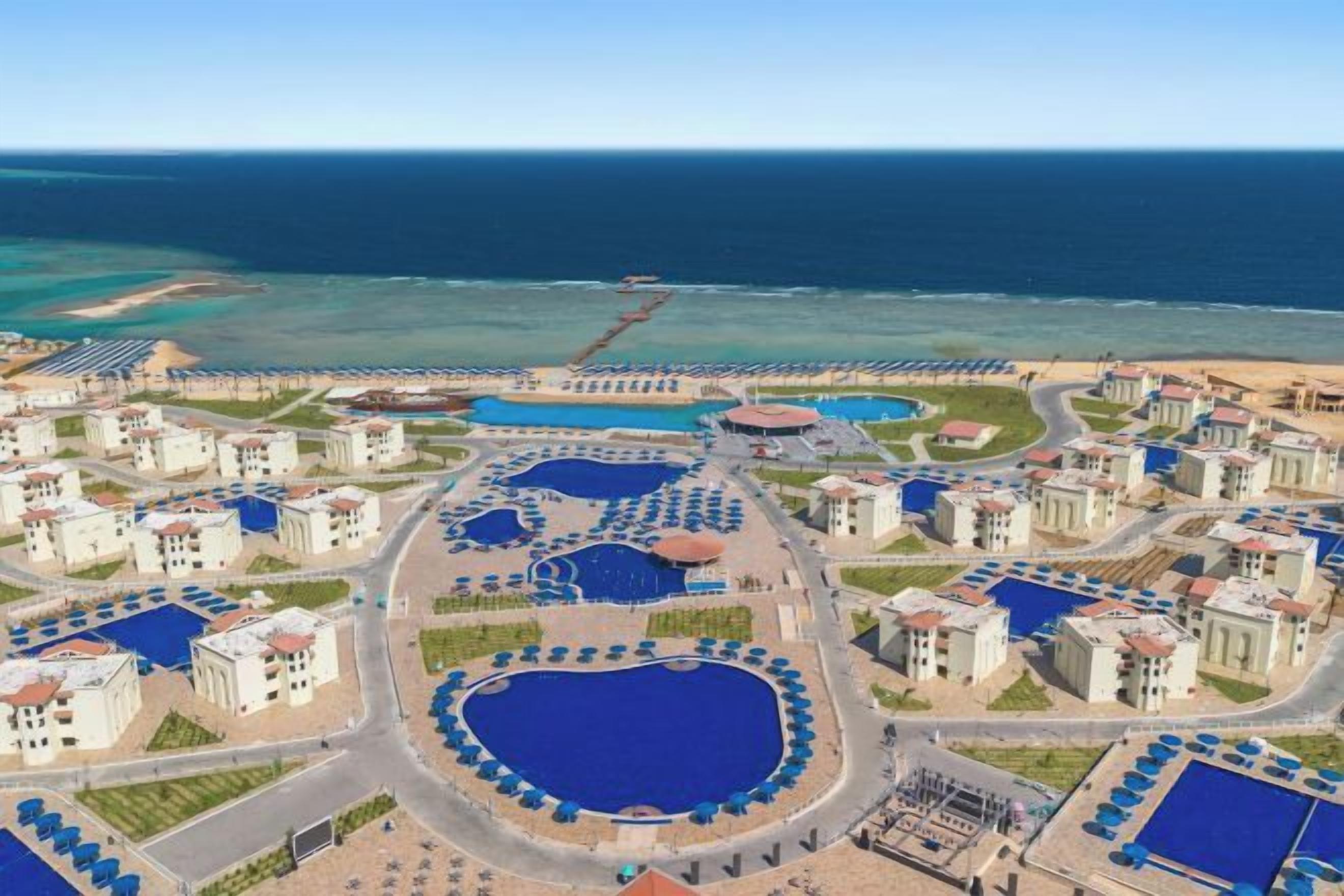 A resort with multiple swimming pools, beachfront villas, and a beach.