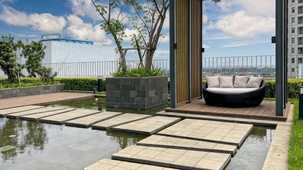 A modern outdoor seating area with a water feature, stone steps, and a view of the city skyline. - Newly Studio Apt w/ Pool, Gym Netflix (South Jakarta)