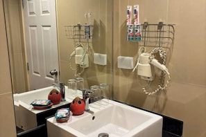 Une salle de bain équipée d’un lavabo, d’un miroir et d’un porte-serviettes.