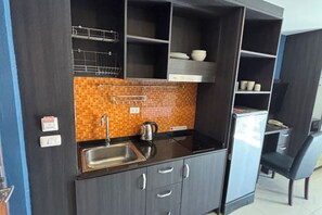 A compact kitchen with a sink, cabinets, and a tiled backsplash. - New Nordic Club 1 Condotel South Pattaya Twin Standard Room (Pattaya)
