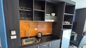 A compact kitchen with a tiled backsplash, a sink, and a kettle. - New Nordic Club 1 Condotel South Pattaya Twin Standard Room (Pattaya)