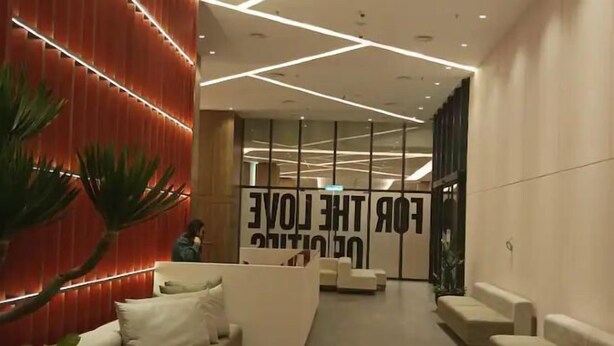 A modern lobby with a reception desk, seating area, and a large wall with motivational text. - Urban Retreat @ The Shore • CBD • Pool (Kota Kinabalu)
