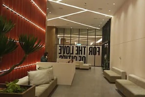 A modern lobby with a reception desk, seating area, and a large wall with a motivational quote. - Urban Retreat @ The Shore • CBD • Pool (Kota Kinabalu)