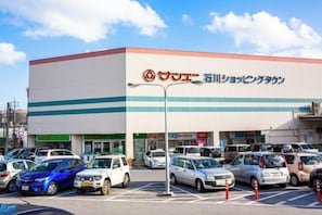 A commercial building with a parking lot filled with cars. - Laulea (Kin)