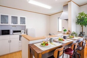 Eine moderne Küche mit weißen Schränken, einer Holz Arbeitsplatte und Barhocker.