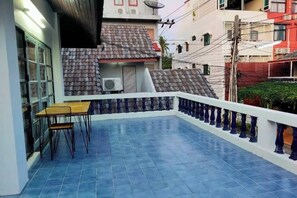 A balcony with a blue tiled floor, a white railing, and a table with chairs. - Japanese style house, Bangsaen (Chon Buri)