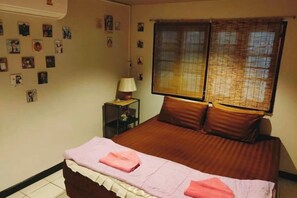 A bedroom with a bed, a nightstand, a lamp, and a window with blinds. - Japanese style house, Bangsaen (Chon Buri)