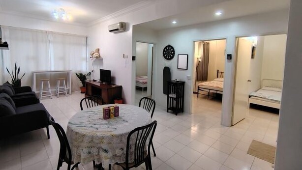 A modern living room with a dining area, a TV, and a cozy seating arrangement. - Permai Ria Home Apartment (Tanjung Bungah)