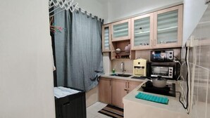 A compact kitchen with a microwave, toaster, and sink. - Permai Ria Home Apartment (Tanjung Bungah)