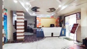 A reception area with a counter, a patterned pillar, and a tiled floor. - Hotel Rachna Tourist lodge  (New Delhi)