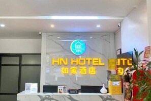 A hotel reception desk with a marble countertop, a neon sign, and a digital display. - HN HOTEL (Bac Ninh)