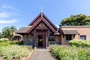 A building with a distinct triangular roof, a central entrance, and a pathway leading to it. - Club Med Albion Villas (Mauritius)