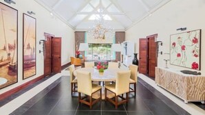 A dining area with a round table, chairs, and a chandelier. - Club Med Albion Villas (Mauritius)