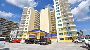 A multi-story hotel with a central entrance and parking area.