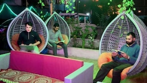 A seating area with three hanging chairs, each occupied by a person. - Dream Valley Kasol (Kasol)