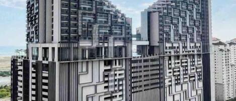 Un moderno edificio de rascacielos con una fachada geométrica distintiva, múltiples balcones y un logotipo destacado en la base.