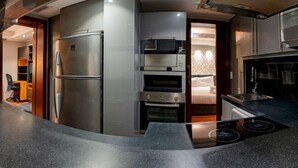 Une cuisine moderne équipée d’un four encastré, d’un réfrigérateur et d’un four à micro-ondes.
