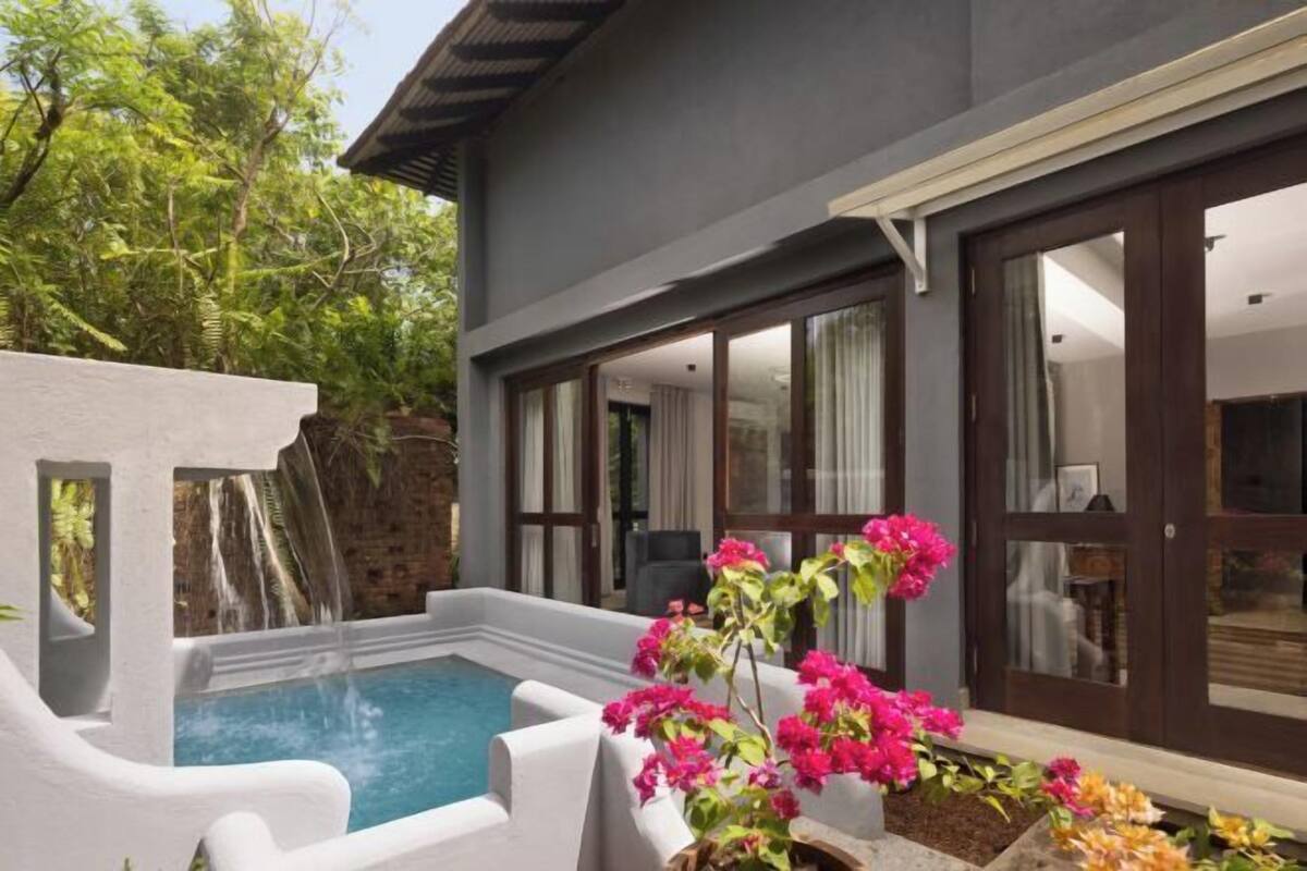 A modern building with a pool, large windows, and a waterfall feature.